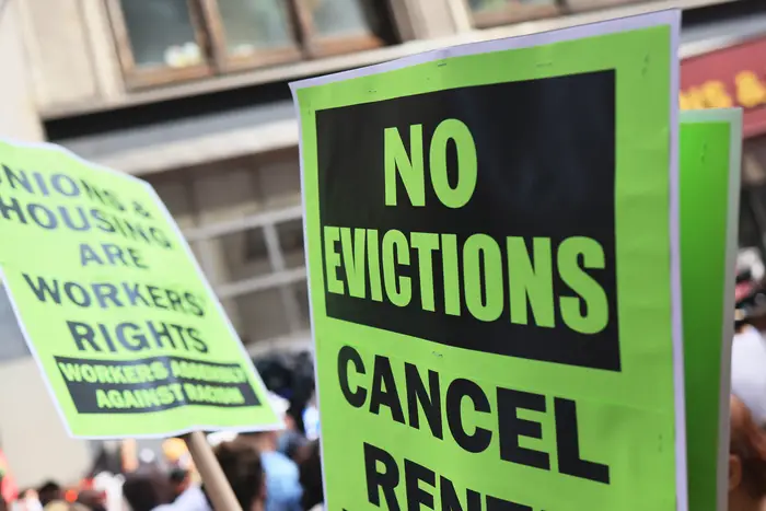 Neon green signs display messages against evictions.